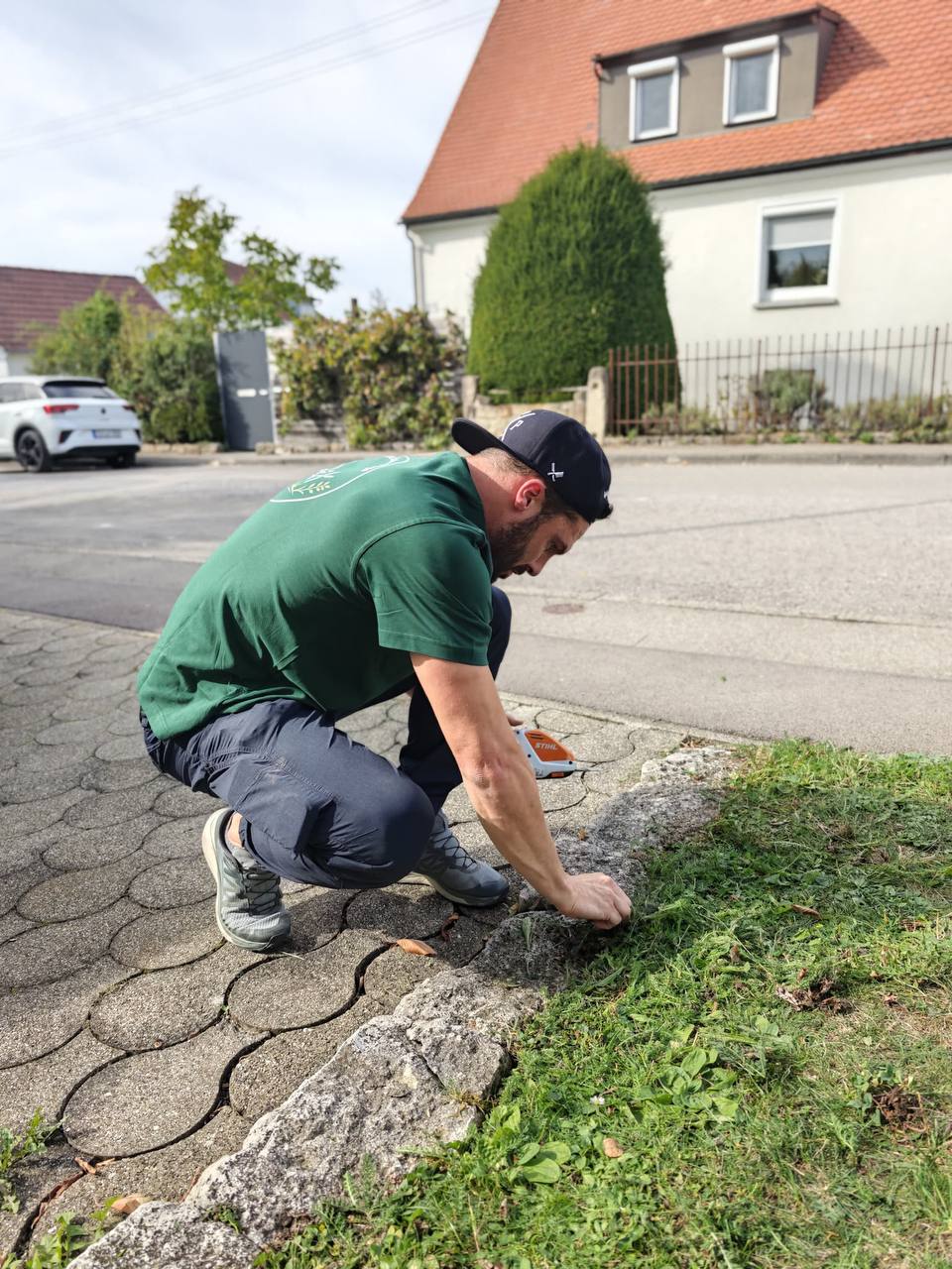 Jochen schneidet Rasenkanten an einer Natursteinkante